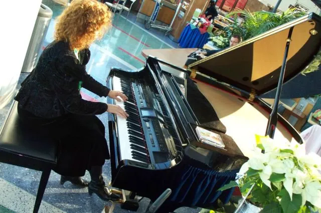 Nancy playing piano at Portland International Airport